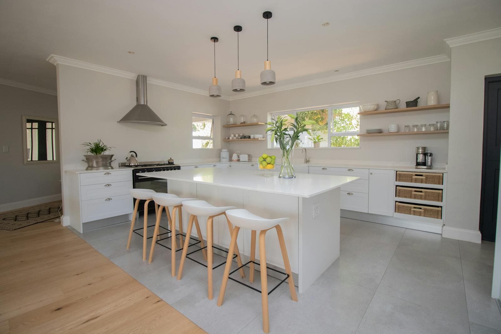 Modern kitchen remodel with subway tile, white cabinets, and island with pendants